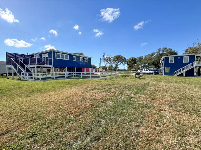 a view of a swimming pool with lawn chairs and a yard