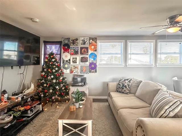 a living room with furniture a flowers and a flat screen tv
