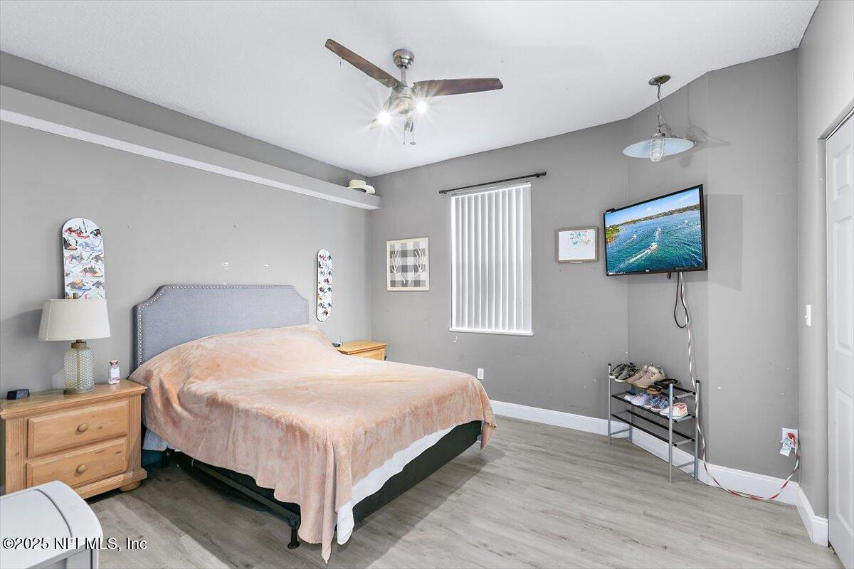 55214 Yellow Jacket Drive Callahan, FL 32011 - Photo 17 of 32 a bedroom with a bed and a flat tv screen on dresser