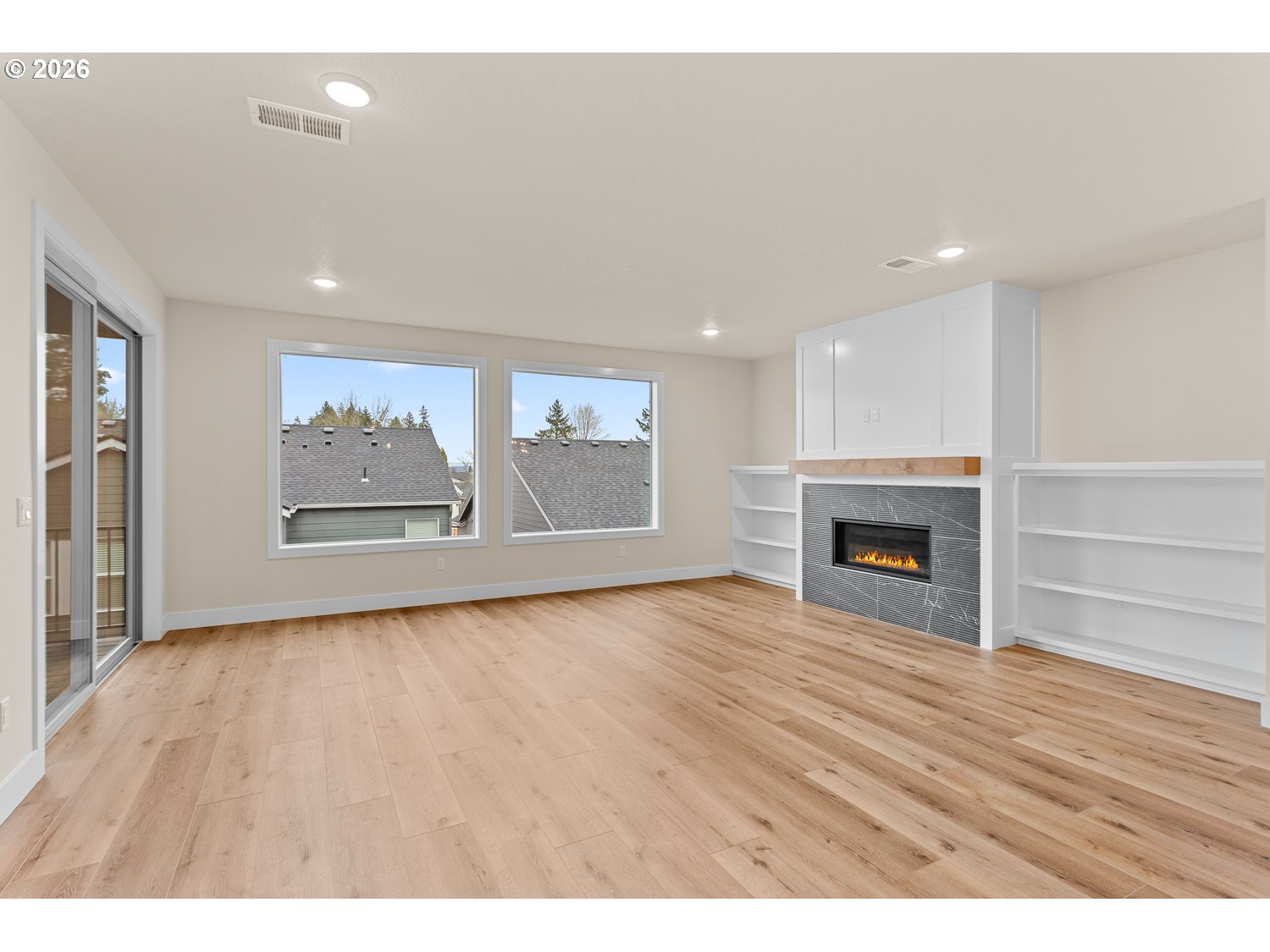 15666 Southwest Everglade Avenue Tigard, OR 97224 - Photo 20 of 45 a view of empty room with wooden floor and fireplace