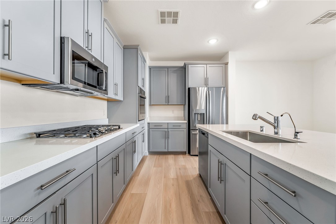 2555 Hampton Road, Unit 10108 Henderson, NV 89052 - Photo 10 of 23 Gleaming stone countertops and sleek cabinetry define this contemporary culinary workspace with natural wood flooring.