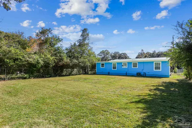 a view of a big yard with a house in the background