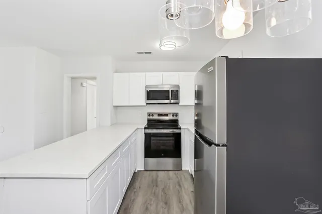 a kitchen with a sink stainless steel appliances a refrigerator and a stove