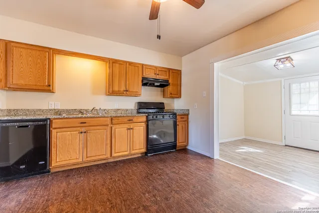 a kitchen with granite countertop cabinets stainless steel appliances and a window