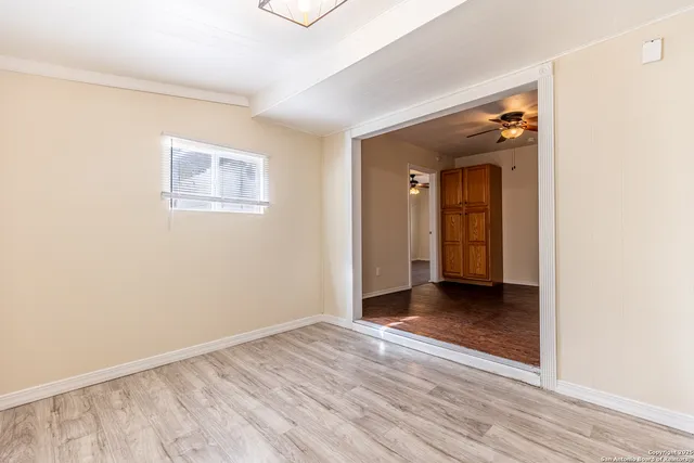 a view of an empty room with wooden floor