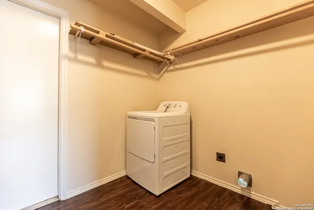 a utility room with closet and wooden floor