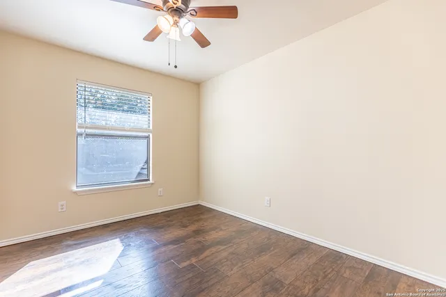 an empty room with a window and wooden floor