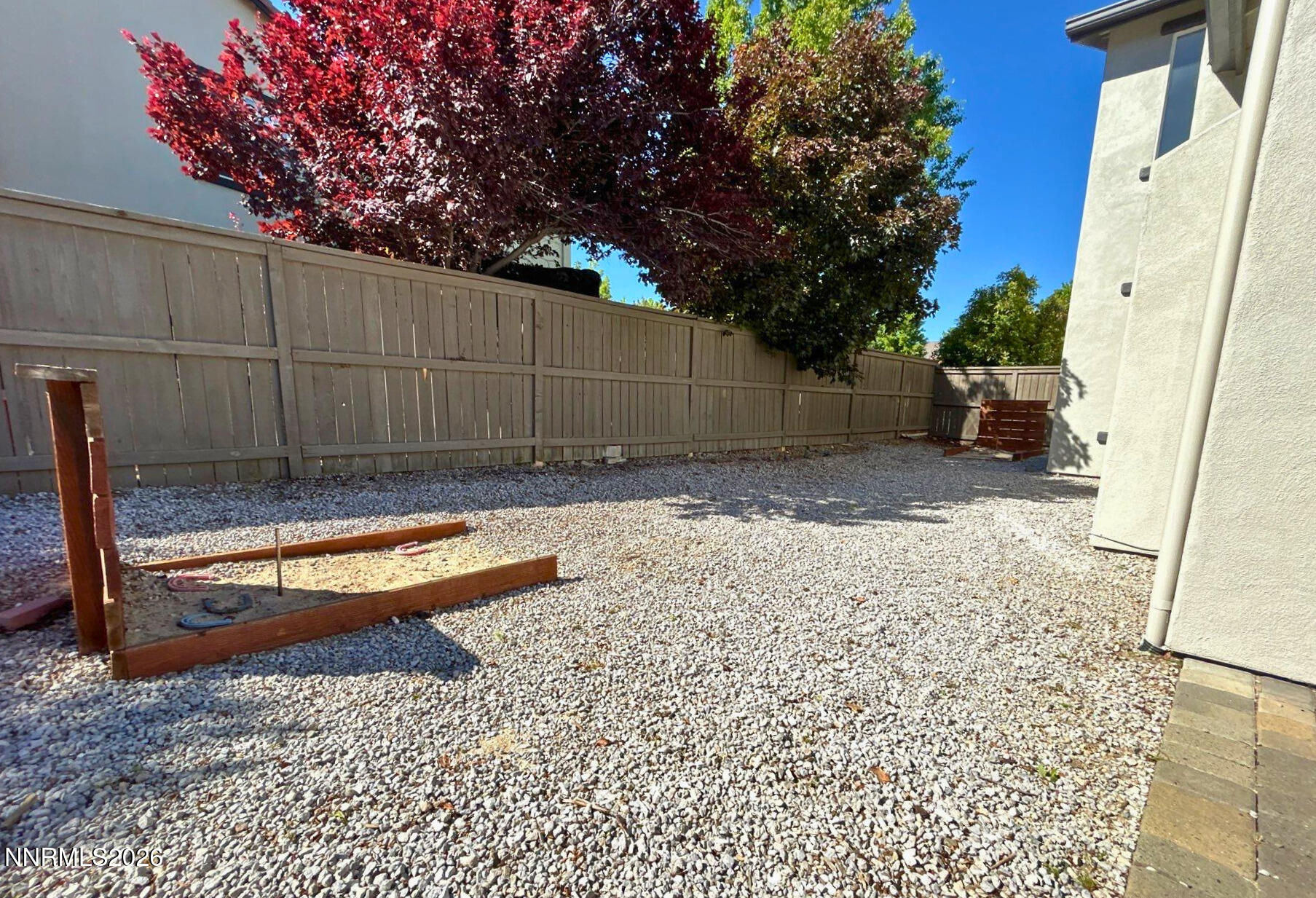 635 Ubaldo Court Reno, NV 89521 - Photo 21 of 22 a view of a backyard with large trees and wooden fence