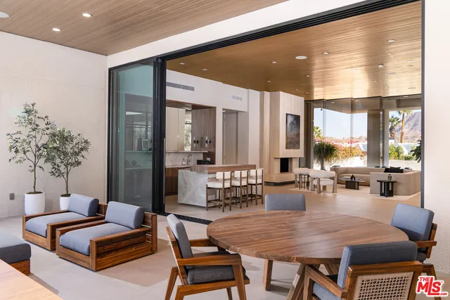 a living room with furniture kitchen view and a large window