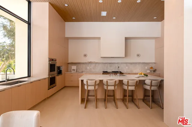a kitchen with a sink and chairs