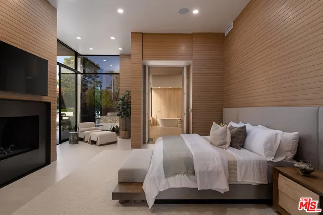 a bedroom with a bed a couch and a flat tv screen