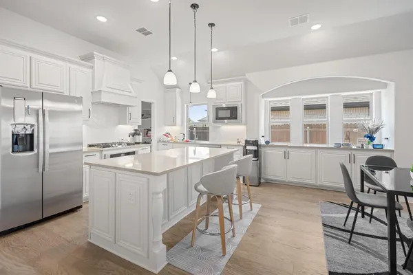 a kitchen with kitchen island white cabinets and stainless steel appliances