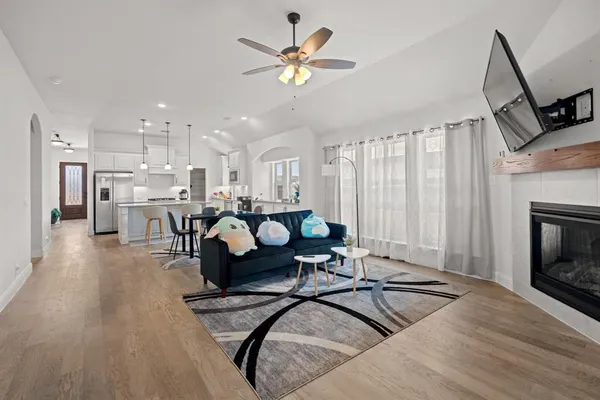 a kitchen with stainless steel appliances granite countertop a sink a stove a refrigerator cabinets and chairs