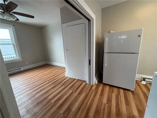 a view of empty room with wooden floor