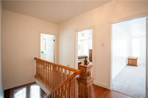a view of a hallway with wooden floor and stairs