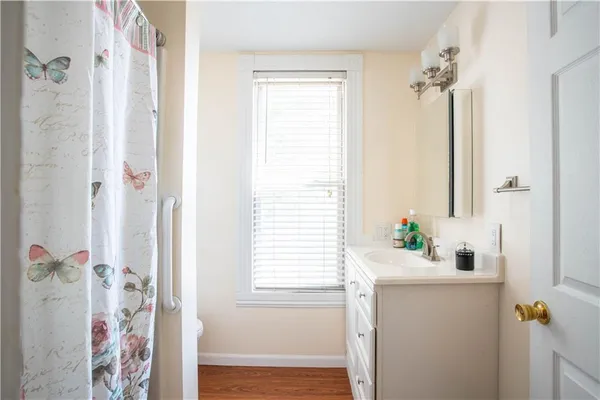 a bathroom with a bathtub a shower and a window