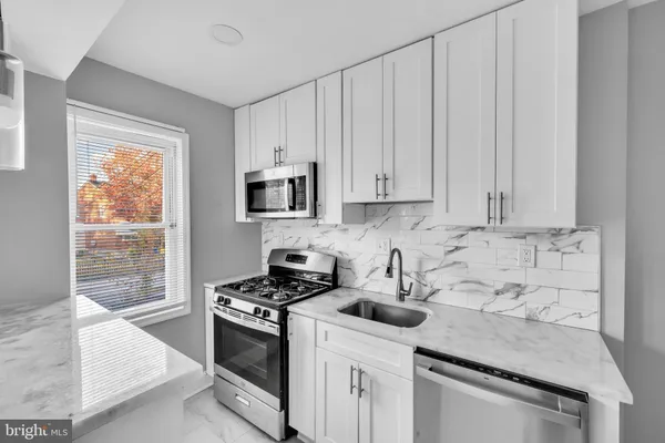 a kitchen with granite countertop white cabinets and white appliances