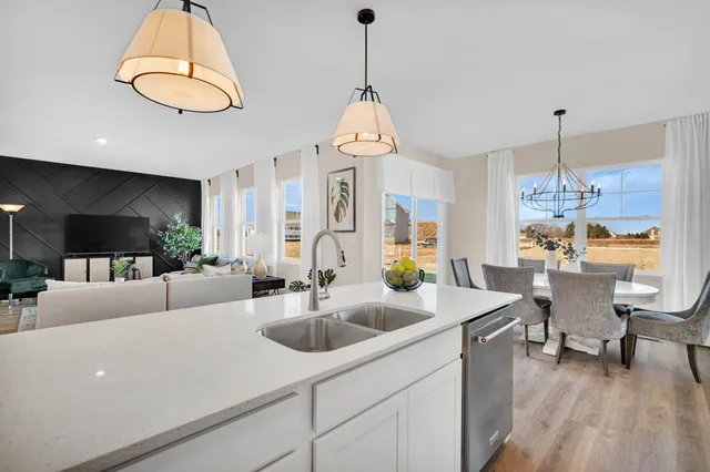 a living room with kitchen island furniture and a chandelier