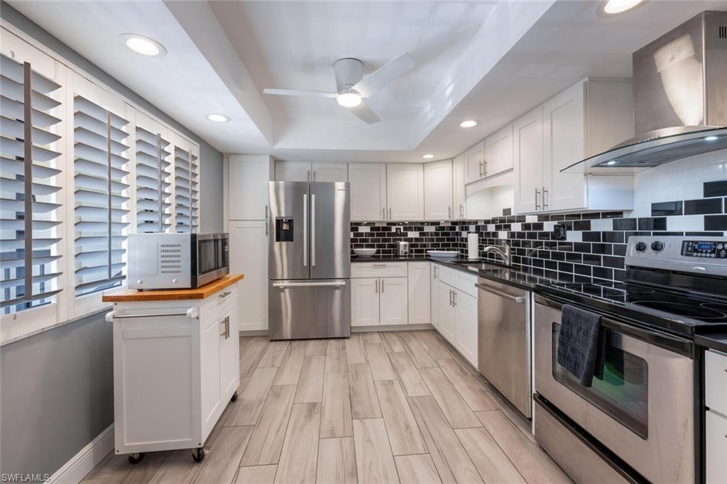 413 Augusta Boulevard, Unit 302 Naples, FL 34113 - Photo 14 of 39 a large kitchen with stainless steel appliances granite countertop a stove and a sink