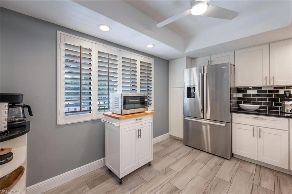 413 Augusta Boulevard, Unit 302 Naples, FL 34113 - Photo 15 of 39 a kitchen with stainless steel appliances a refrigerator sink and cabinets
