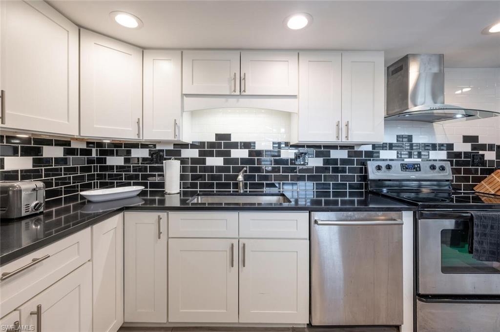 413 Augusta Boulevard, Unit 302 Naples, FL 34113 - Photo 17 of 39 a kitchen with stainless steel appliances granite countertop a sink and cabinets