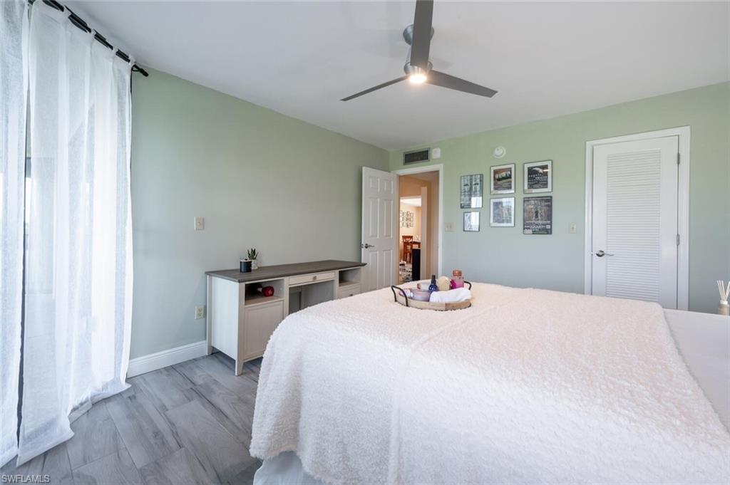 413 Augusta Boulevard, Unit 302 Naples, FL 34113 - Photo 19 of 39 a bedroom with a bed and a chandelier
