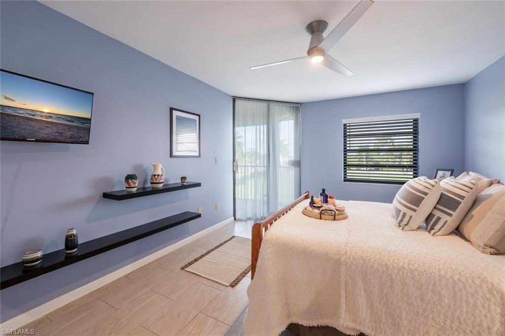 413 Augusta Boulevard, Unit 302 Naples, FL 34113 - Photo 25 of 39 a bedroom with a bed and a chandelier