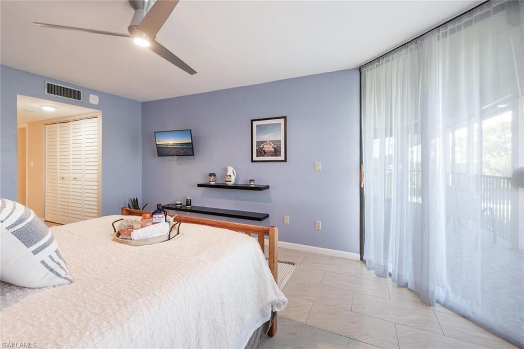 413 Augusta Boulevard, Unit 302 Naples, FL 34113 - Photo 26 of 39 a bedroom with a bed and a lamp