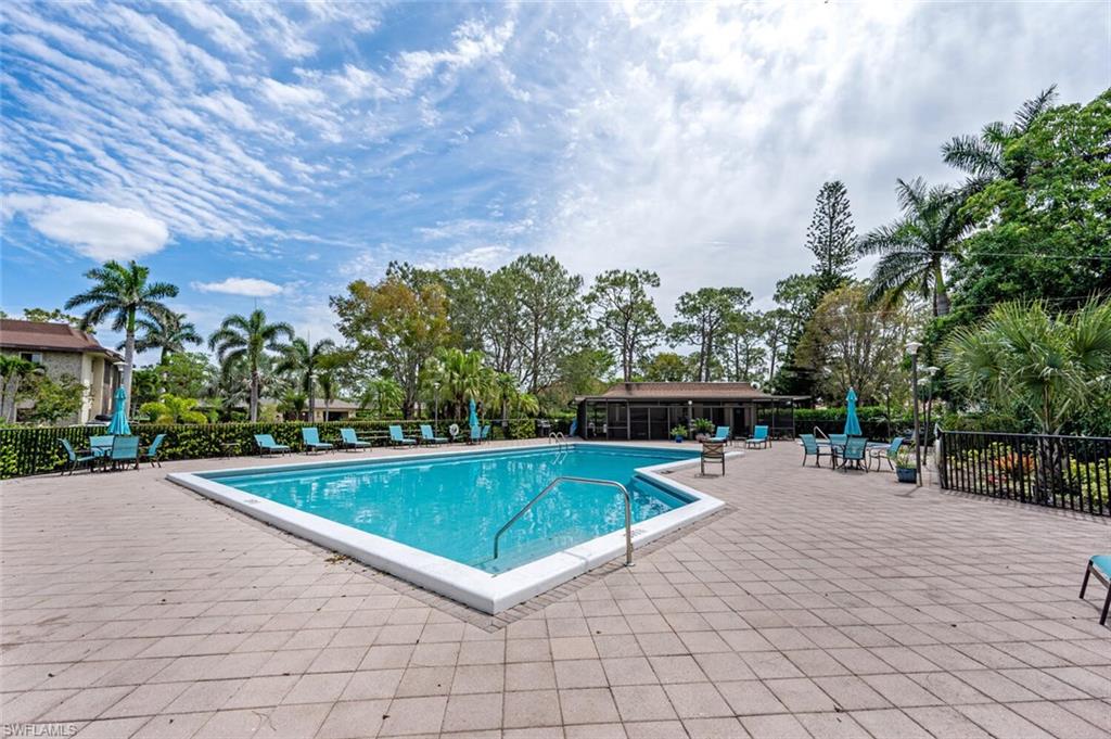 413 Augusta Boulevard, Unit 302 Naples, FL 34113 - Photo 35 of 39 a view of a swimming pool with a patio and a garden