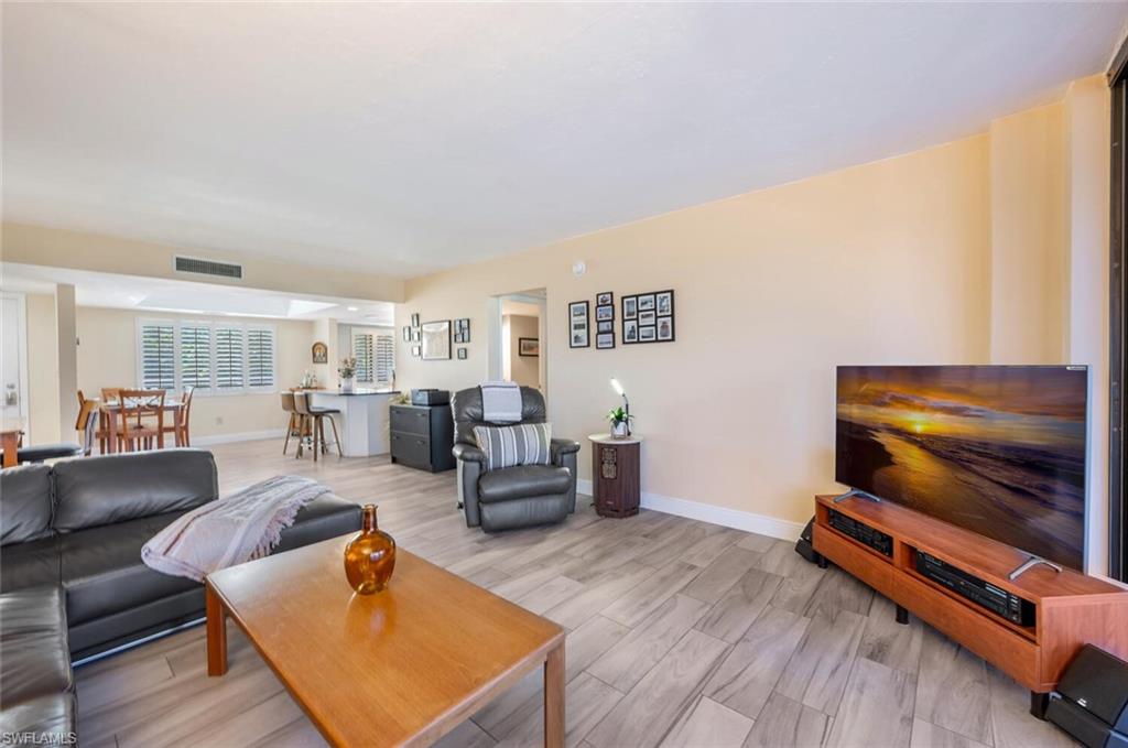 413 Augusta Boulevard, Unit 302 Naples, FL 34113 - Photo 6 of 39 a living room with furniture and a flat screen tv