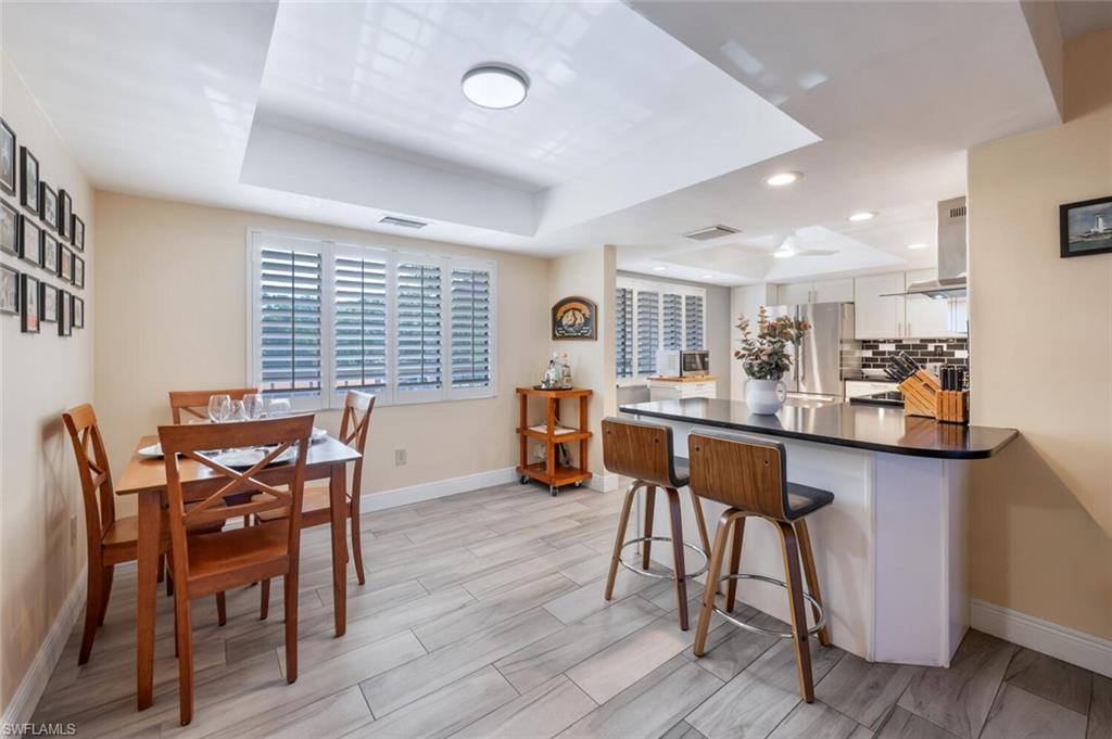 413 Augusta Boulevard, Unit 302 Naples, FL 34113 - Photo 9 of 39 a dining room with furniture and wooden floor