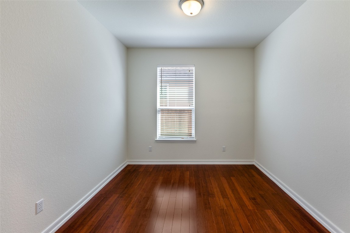 2950 East Old Settlers Boulevard, Unit 82 Round Rock, TX 78665 - Photo 14 of 31 wooden floor in an empty room with a window