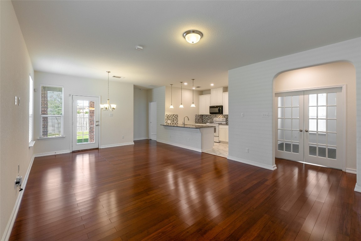 2950 East Old Settlers Boulevard, Unit 82 Round Rock, TX 78665 - Photo 4 of 31 a view of an empty room and kitchen with wooden floor