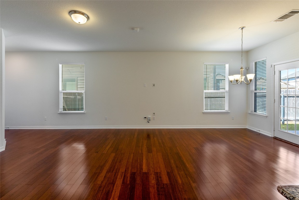 2950 East Old Settlers Boulevard, Unit 82 Round Rock, TX 78665 - Photo 6 of 31 an empty room with wooden floor and windows
