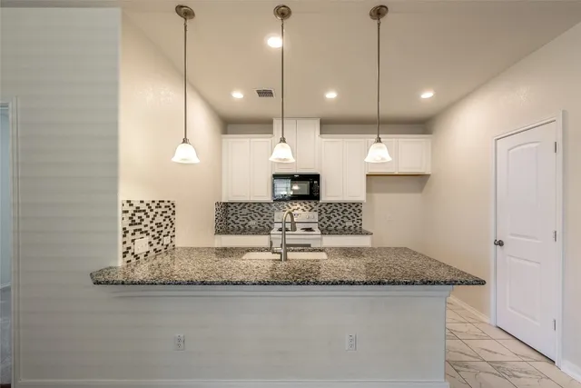 a large kitchen with a sink and chandelier