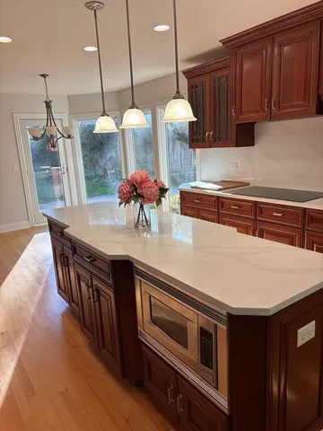 a kitchen with stainless steel appliances granite countertop a stove a sink and a wooden floors