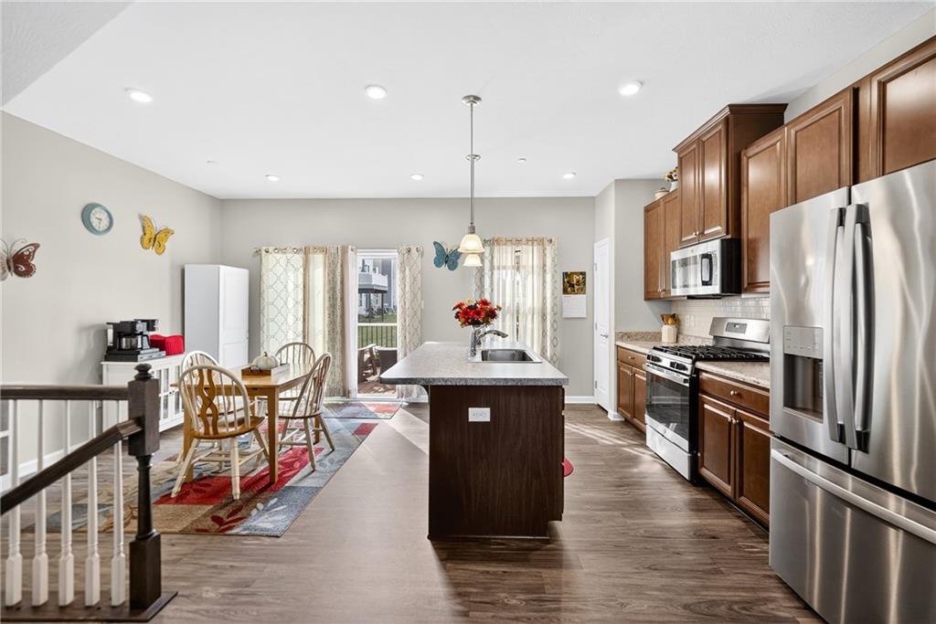 2019 Cade Drive Monaca, PA 15061 - Photo 14 of 37 a kitchen with stainless steel appliances granite countertop a refrigerator a stove top oven a dining table and chairs with wooden floor