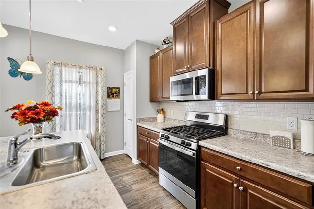 a kitchen with stainless steel appliances granite countertop a sink stove and refrigerator