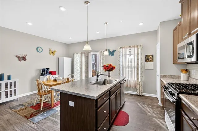 a kitchen with stainless steel appliances granite countertop a kitchen island a stove and a refrigerator