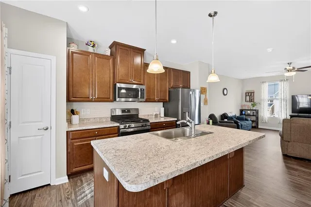 a kitchen with kitchen island granite countertop a sink stove and wooden floor