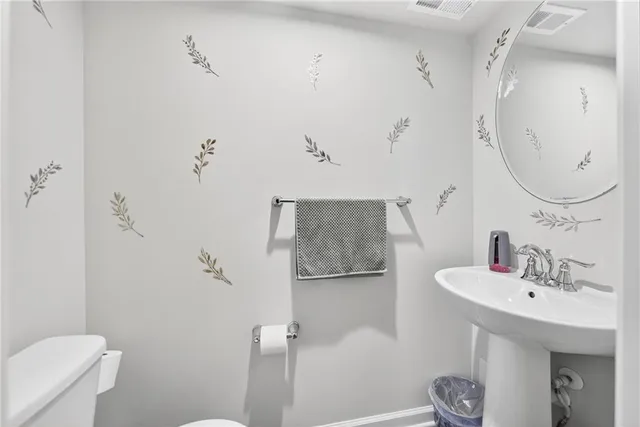 a bathroom with a sink a toilet and shower curtain