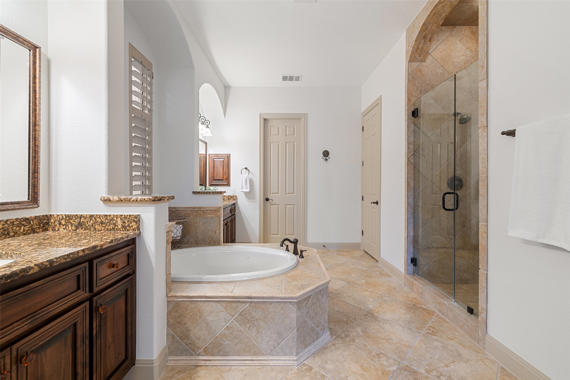 4105 Vail Divide Austin, TX 78738 - Photo 28 of 40 a bathroom with a granite countertop sink a mirror and a bathtub