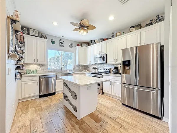 a kitchen with a refrigerator a sink and dishwasher with wooden floor