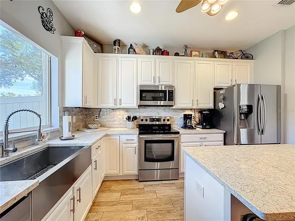 a kitchen with kitchen island granite countertop a stove sink and refrigerator