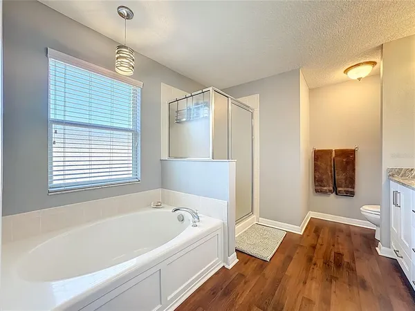 a bedroom with a bed a tv and wooden floor