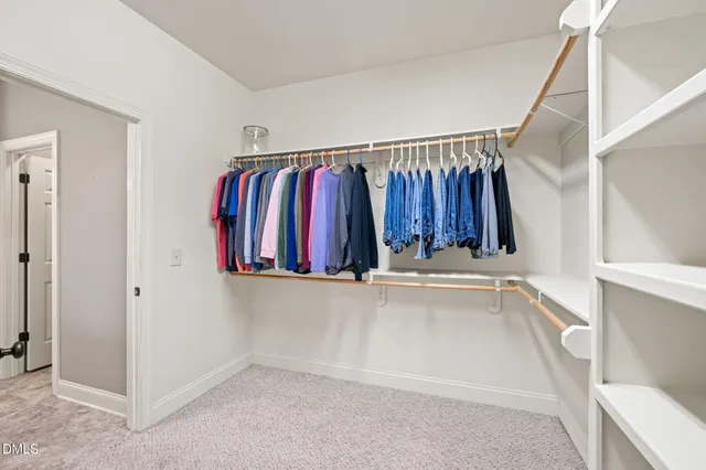 a view of walk in closet with clothes and shoes
