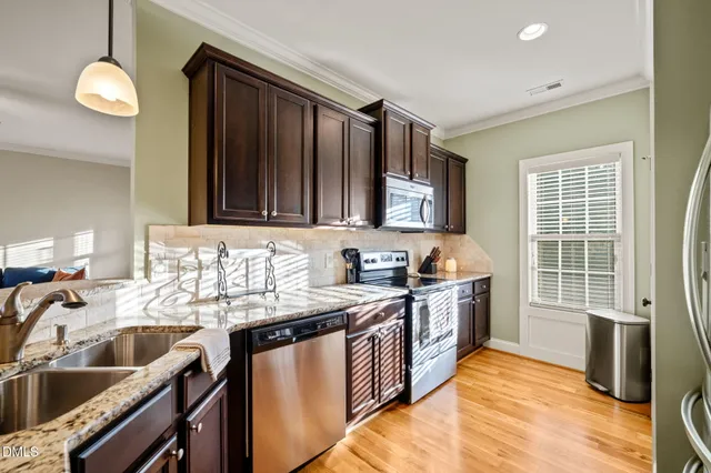 a kitchen with granite countertop a sink stove and cabinets
