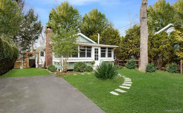 a front view of a house with a yard and trees