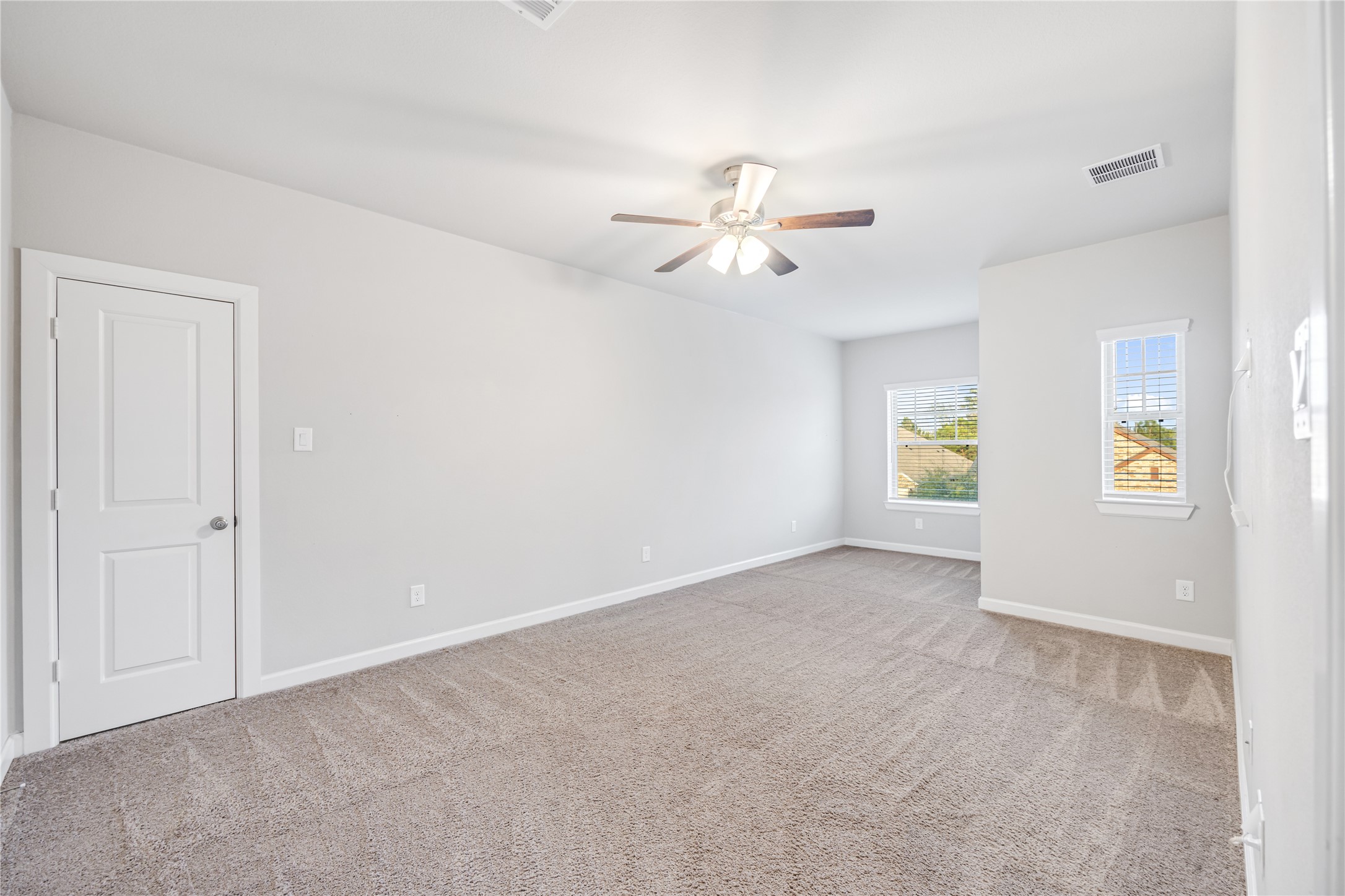 3604 Magnolia Crest Lane Spring, TX 77386 - Photo 36 of 50 This spacious, carpeted bedroom features neutral walls, a ceiling fan, and ample natural light from two large windows, creating a bright and comfortable space.
