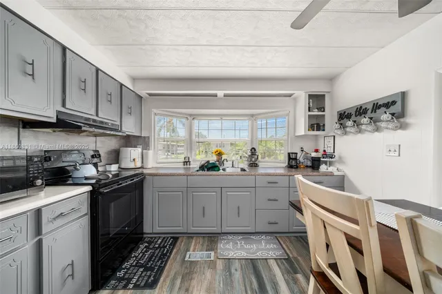 a kitchen with granite countertop cabinets stainless steel appliances a sink and a window
